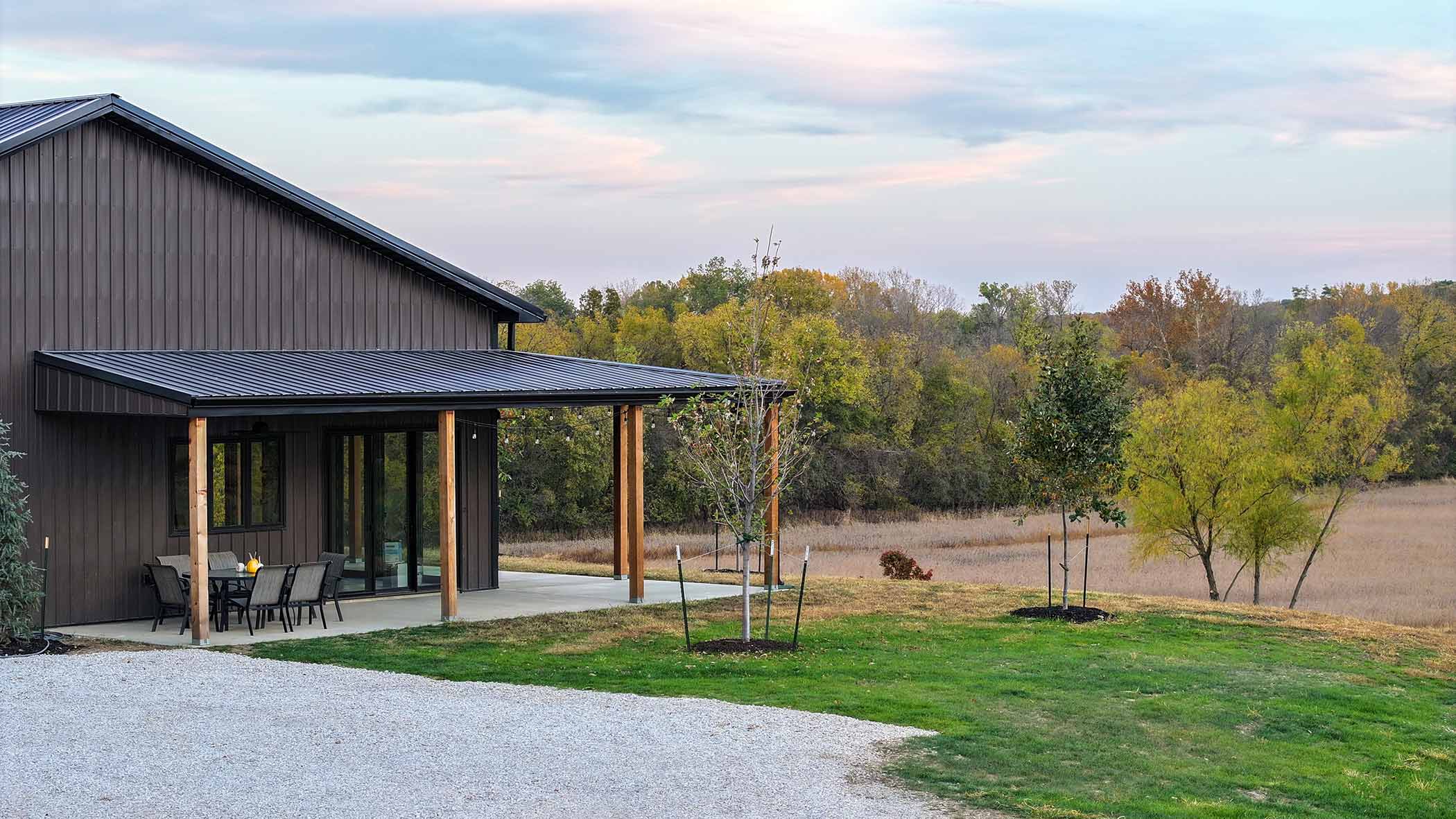 Red Bird Ranch lodge exterior — dark board-and-batten siding, covered porch with cedar posts