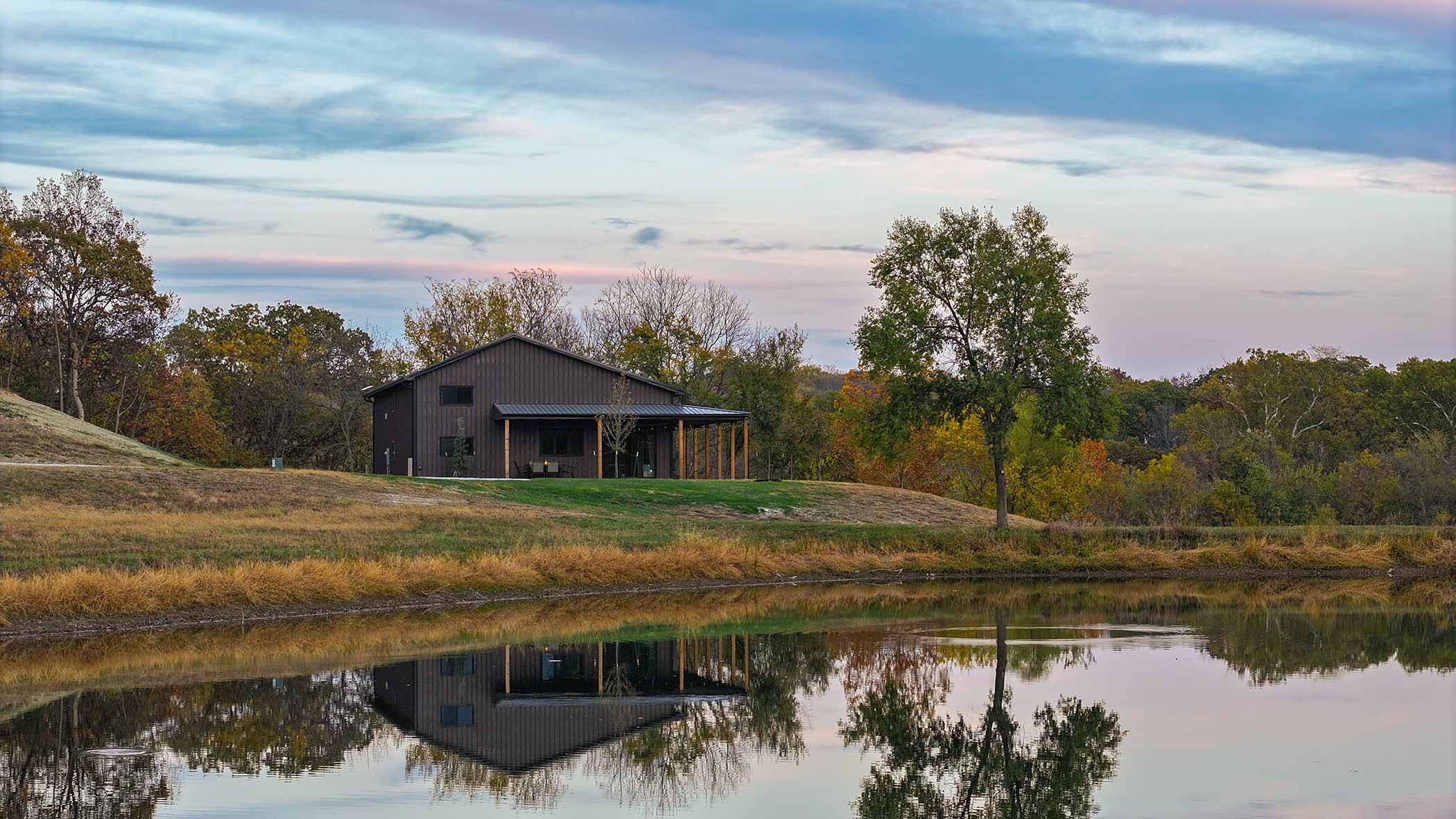 Red Bird Ranch event lodge reflected in the lake at dusk
