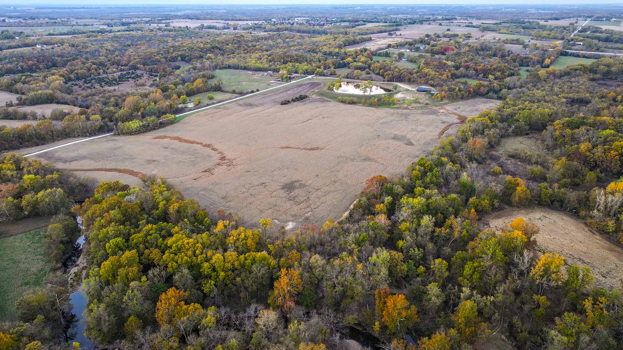 Aerial view of all 100 acres of Red Bird Ranch — fields, woodland, and conservation wetland