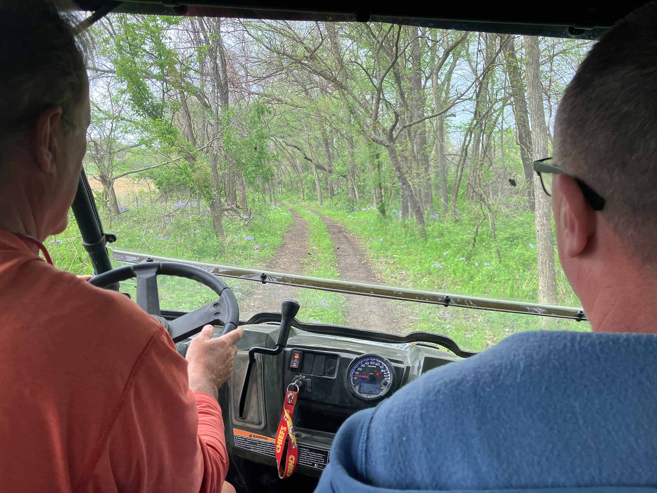 ATV through wooded bluebell trail at Red Bird Ranch — spring wildflowers on forest floor