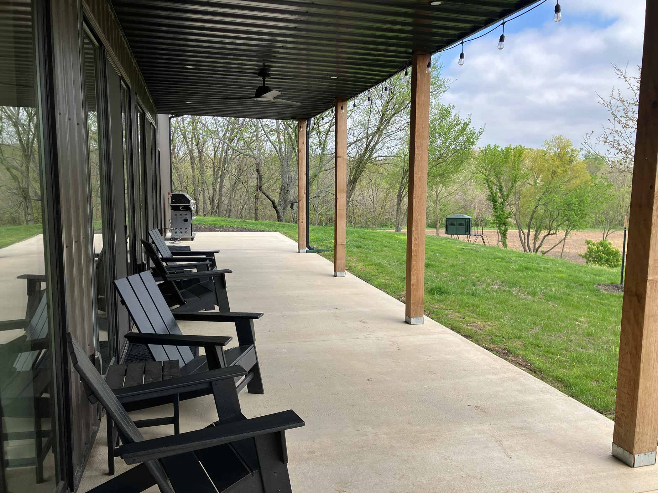 Covered porch with Adirondack chairs and string lights