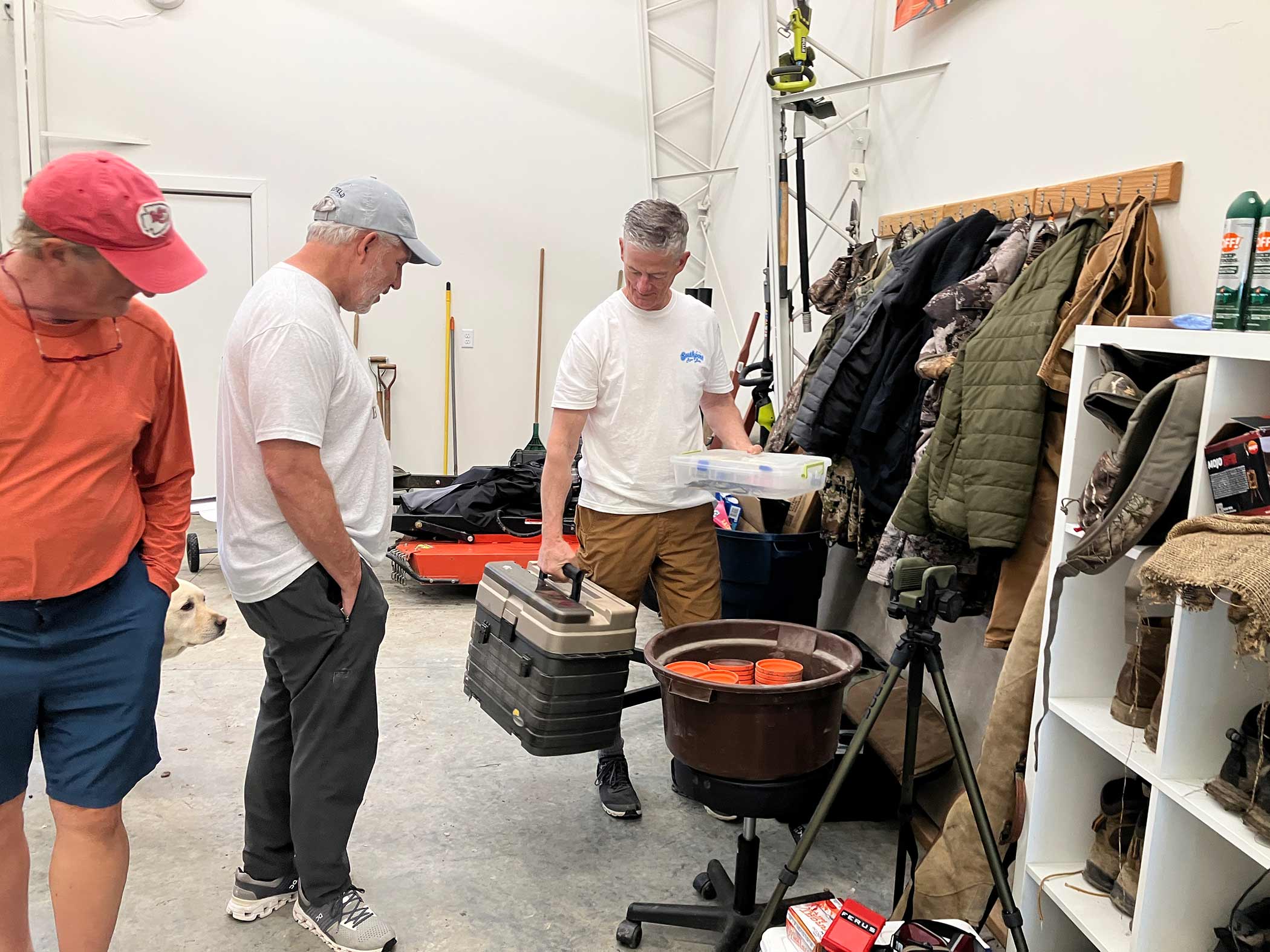 Gear room at Red Bird Ranch — tackle boxes, camo jackets, fishing rods, duck decoys