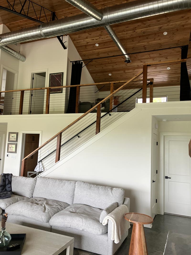 Red Bird Ranch staircase — cable railing, wood handrail, vaulted ceiling above