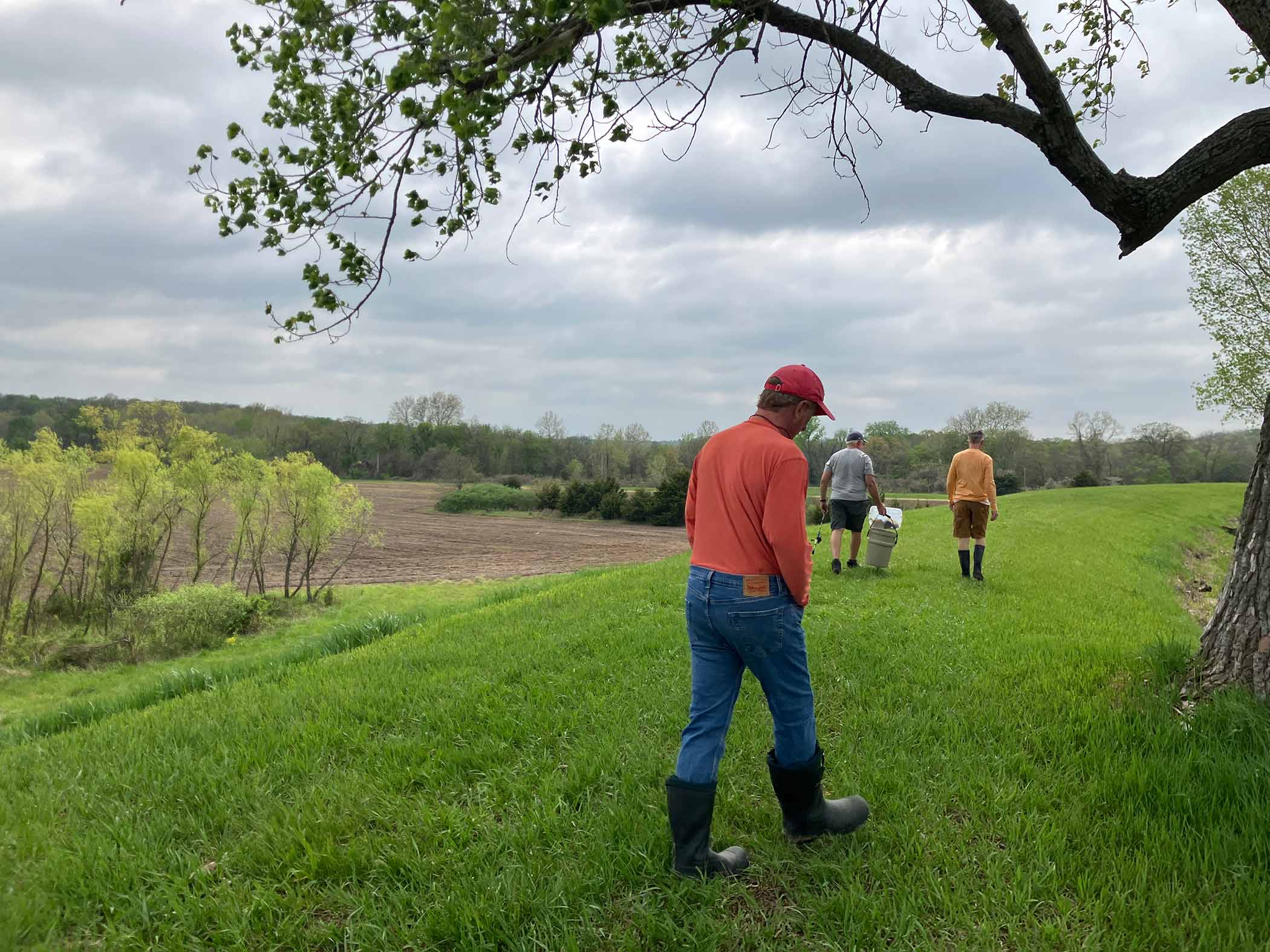 Guests walking toward the lake with rubber boots and fishing gear